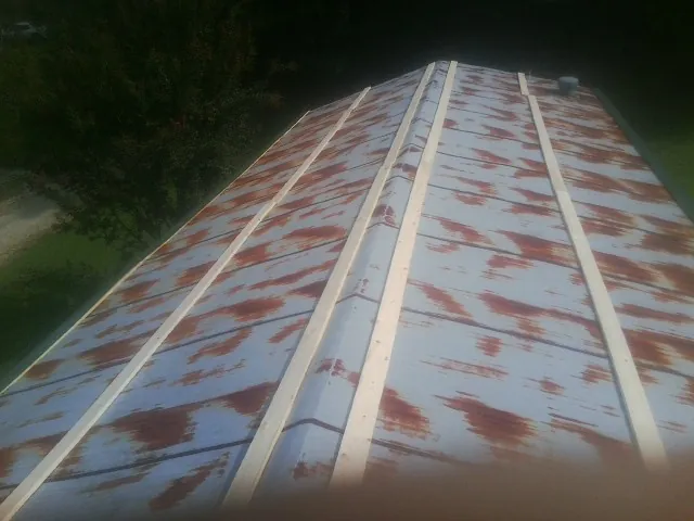 Rusted metal roof panels with new wood purlins before replacement — Storm Damage Roof Repair in Oriska by Roofing Brothers