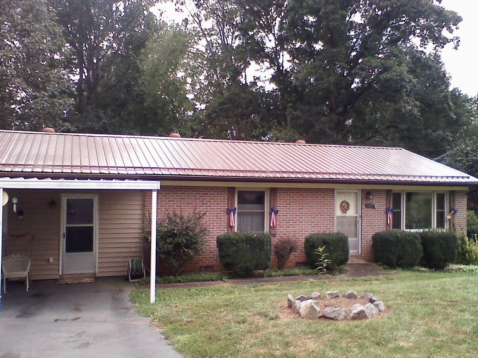 Bronze metal roof and carport on a brick ranch home — Roof Repair work by our crew in Oriska